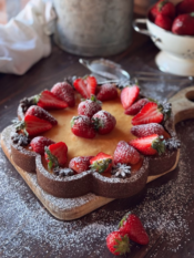 Crostata di frolla al cacao con cuore di fragole, crema di ricotta e decorazione di frutta