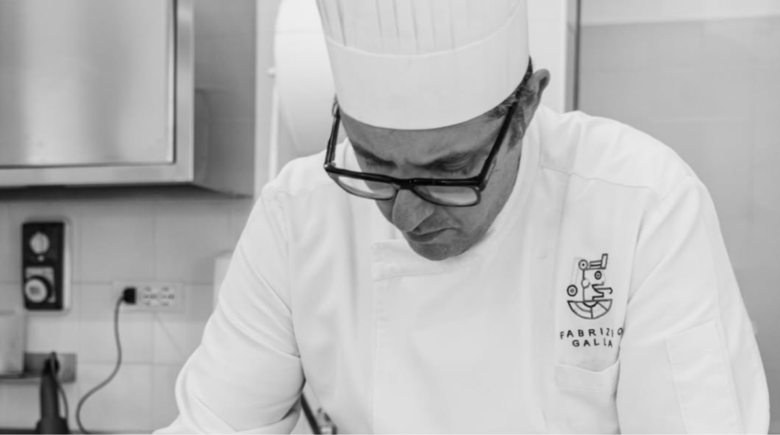 Primo piano in bianco e nero dello chef Fabrizio Galla al lavoro.