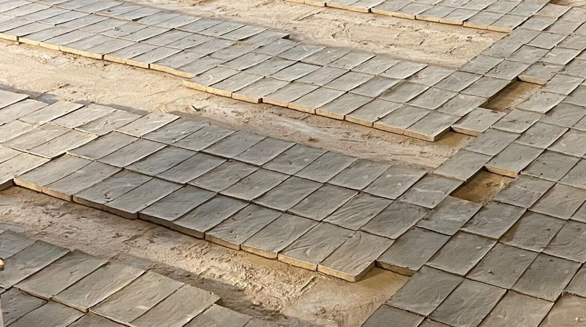 File ordinate di mattoni in terracotta fatti a mano lasciati ad asciugare sul pavimento di una fornace artigianale