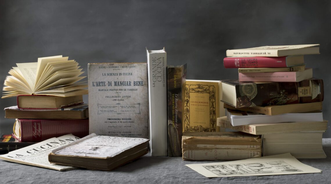 Una pila di libri di cucina di diverse epoche su un tavolo