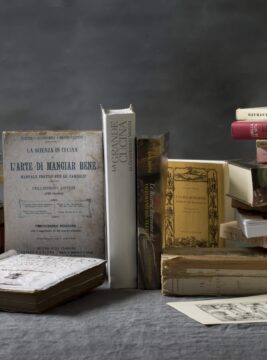 Una pila di libri di cucina di diverse epoche su un tavolo