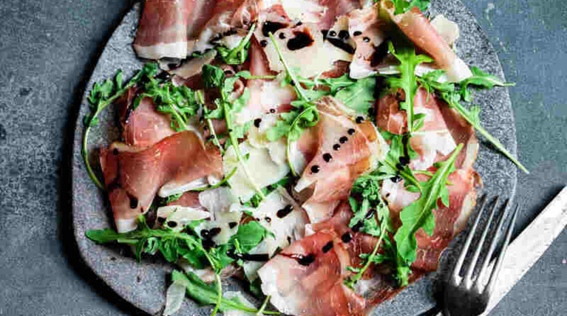 piatto con insalata di rucola, grana e speck alto adige igp