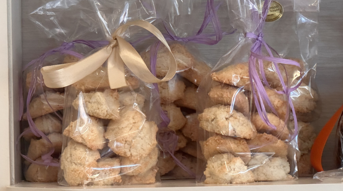 Confezioni trasparenti di Amaretti di Spilamberto artigianali con fiocchi colorati.