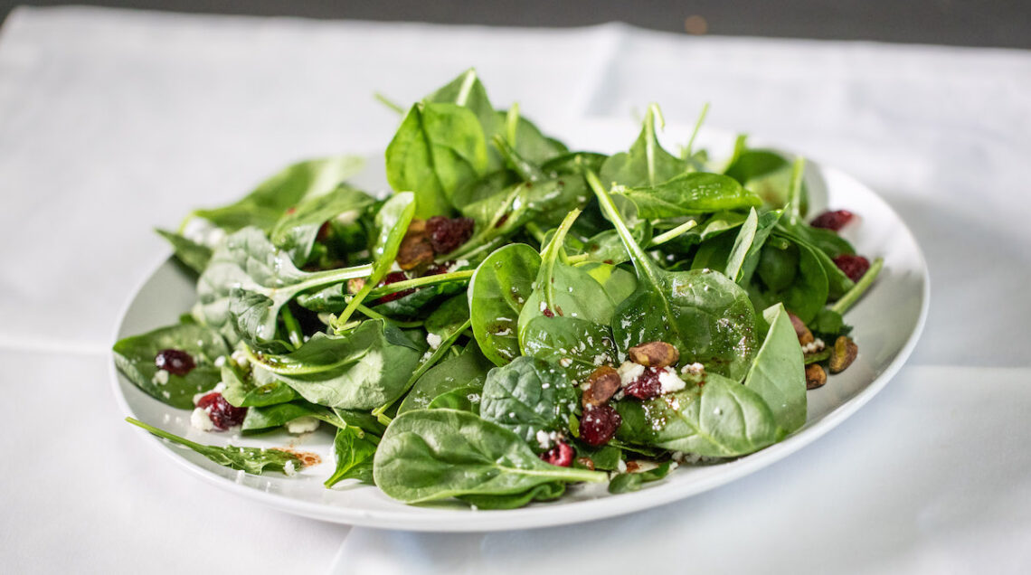 piatto con insalata di spinacini, pistacchi americani e feta