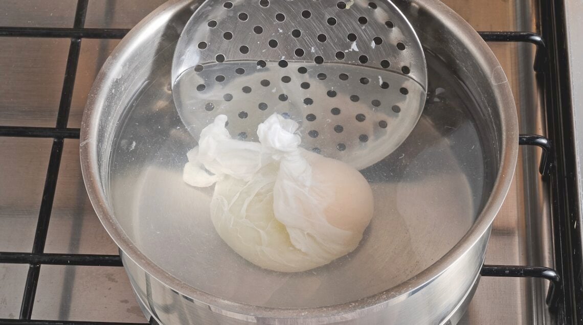 mestolo forato che dà forma all'uovo in camicia in cottura