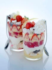 bicchieri con dolce a strati di meringhe, fragole e panna