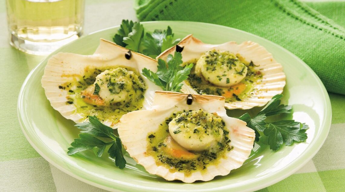 piatto di capesante gratinate disposte nelle loro conchiglie