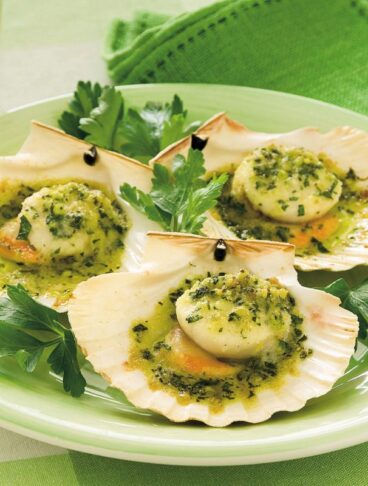 piatto di capesante gratinate disposte nelle loro conchiglie