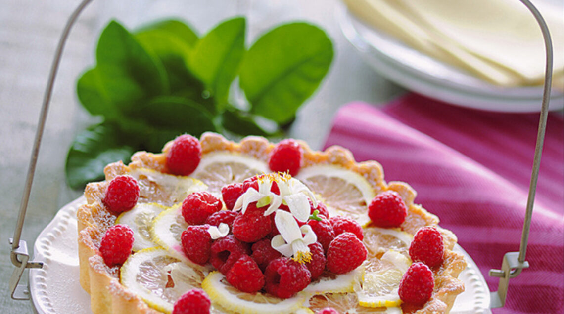 crostata di limoni e lamponi disposta su un piatto