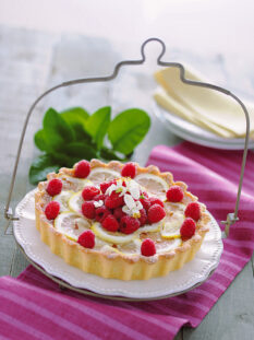 crostata di limoni e lamponi disposta su un piatto