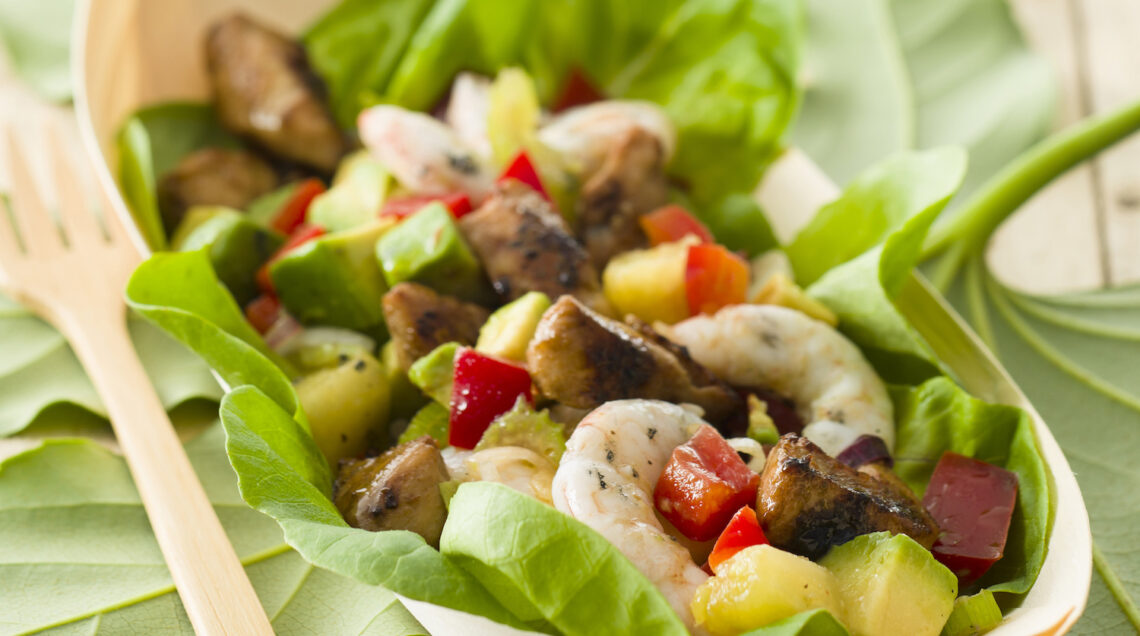 ciotola di lattuga con insalata hawaiana di pollo, gamberi e ananas