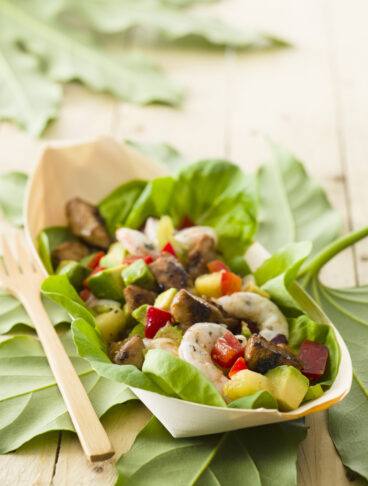 ciotola di lattuga con insalata hawaiana di pollo, gamberi e ananas