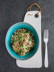 piatto di spaghetti alla carbonara con fave e salame