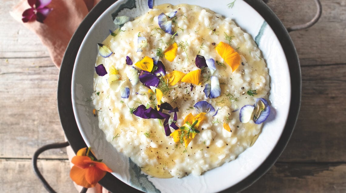 piatto di risotto al formaggio con miele e fiuodi eduli