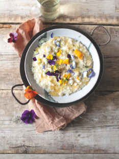 piatto di risotto al formaggio con miele e fiuodi eduli