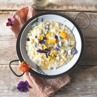 piatto di risotto al formaggio con miele e fiuodi eduli