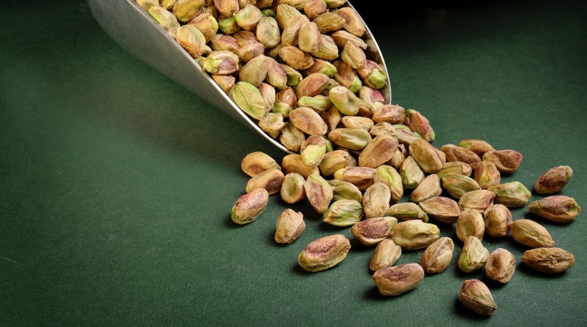 Pistacchi sgusciati su fondo verde