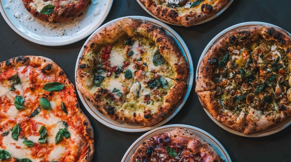 pizze dal cornicione alto assortite, disposte in piatti su un tavolo