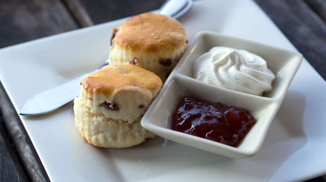 Il tipico Cream Tea britannico, con due scone su un piatto con confettura di fragole e panna montata n due ciotoline