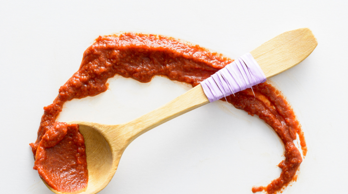 Una cucchiaiata di harissa, spalmata su fondo bianco