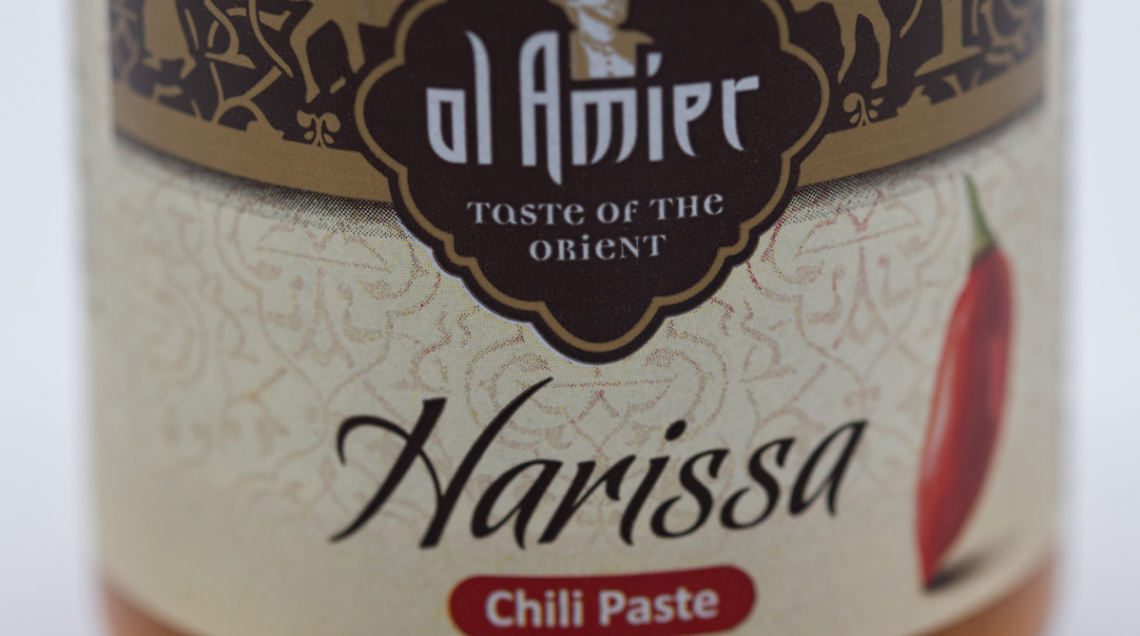 L'etichetta di un vasetto di pasta harissa pronta, con illustrato un peperoncino