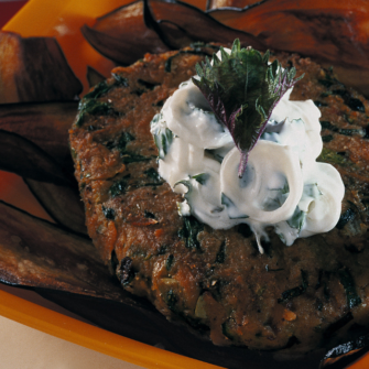 Hamburger vegetariano con salsa di yogurt, in un piatto quadrato e arancione