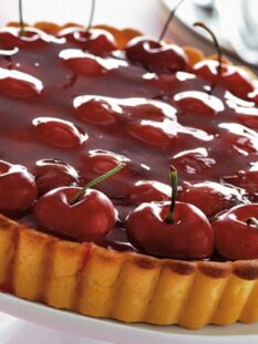 Una grande crostata di ciliegie con base frolla, lucida rossa e accattivante