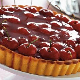 Una grande crostata di ciliegie con base frolla, lucida rossa e accattivante