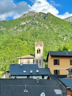 Veduta panoramica di un tipico borgo alpino della Valle Grana con tetti in ardesia e campanile. 