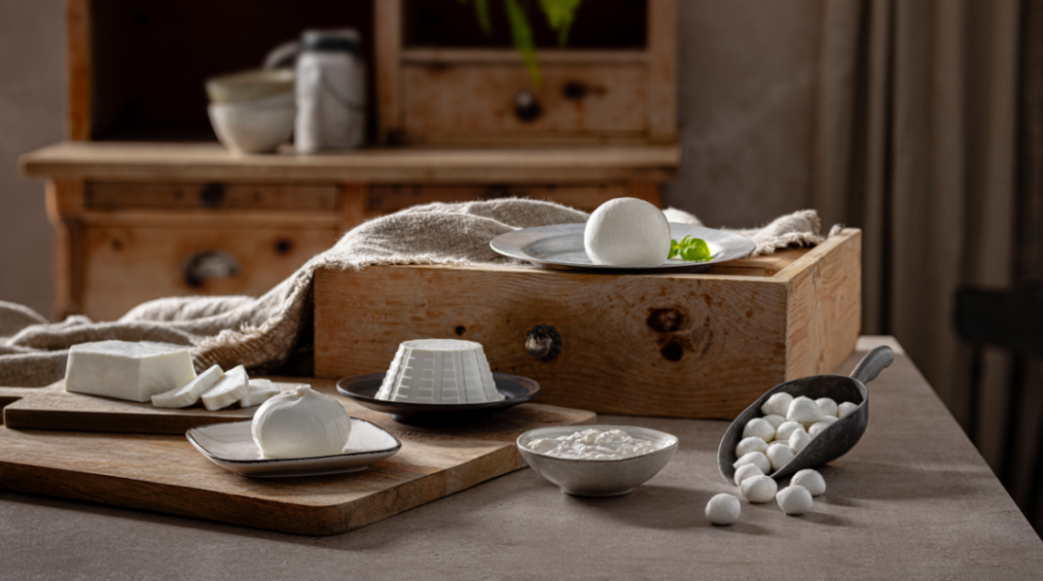 Assortimento di formaggi freschi Brimi: mozzarella, ricotta, burrata e ovoline su un tavolo rustico.