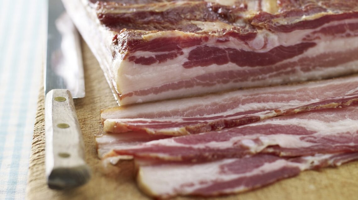 pancetta intera e a fette su un tagliere