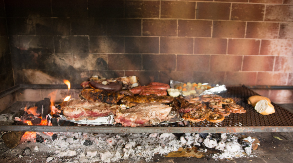 Il grill argentino, l'asado, cuoce la carne su una griglia sollevata dai carboni ardenti