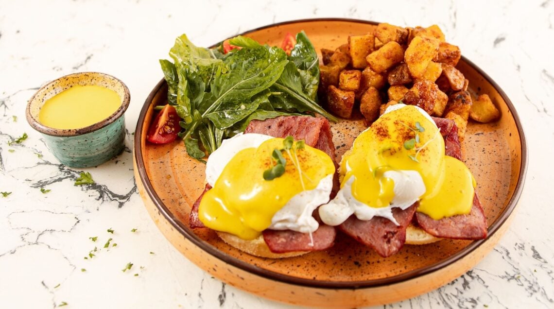Uova alla Benedict su un piatto con contorno