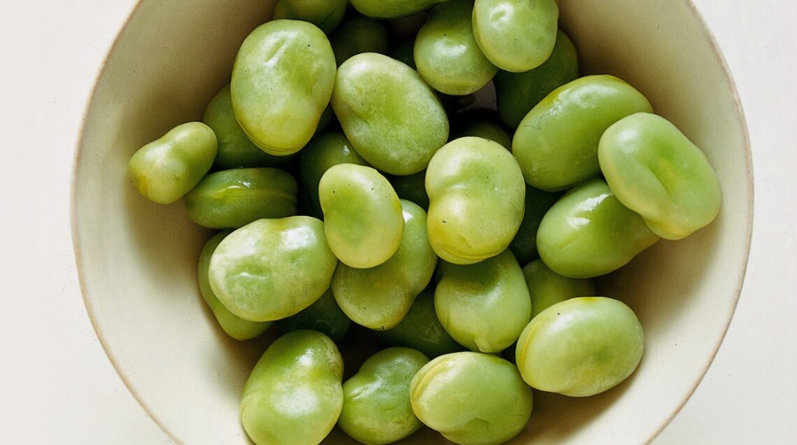 Poche fave sgusciate in una ciotola,la loro forma ricorda i testicoli