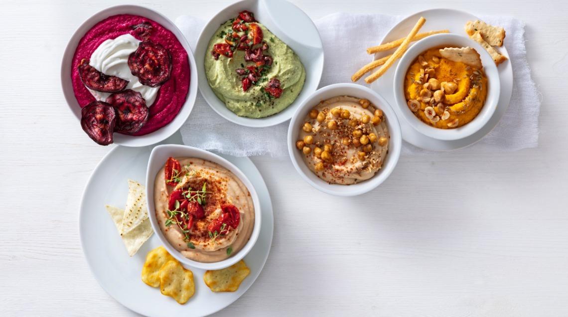 ciotole assortite di hummus disposte su superficie piana, di vari colori e gusti