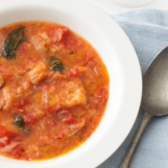 pappa al pomodoro in un piatto con accanto un cucchiaio
