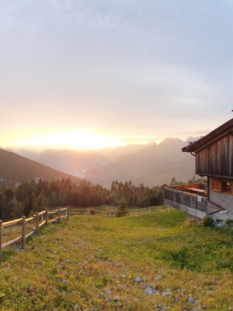 Struttura alpina in legno del Rifugio Pradut a Claut con vista panoramica sulle Dolomiti Friulane al tramonto.