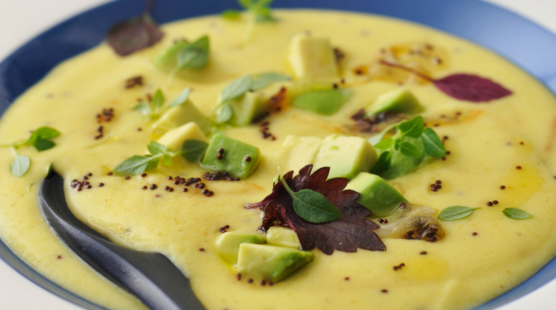 zuppa fredda di kefir e ceci al curry con foglie di insalata e pezzi di avocado