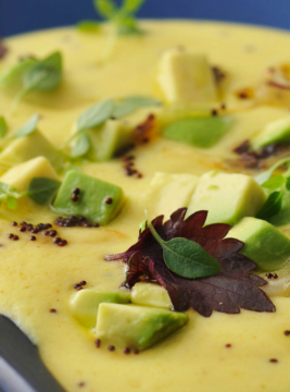 zuppa fredda di kefir e ceci al curry con foglie di insalata e pezzi di avocado