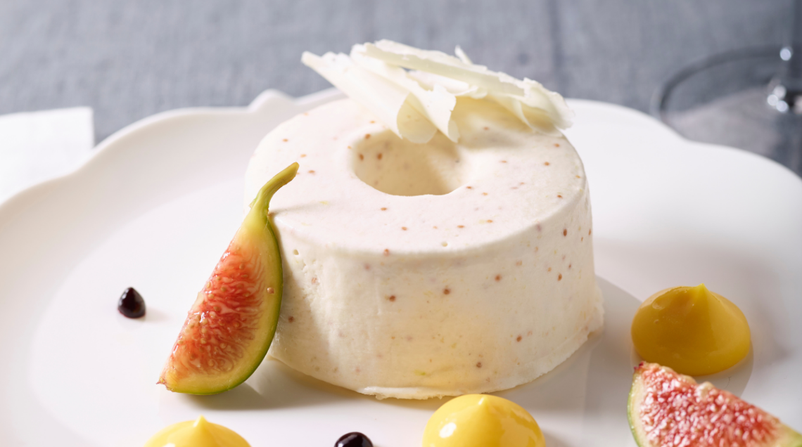 Un semifreddo ai fichi e whisky su piatto bianco con alcuni fichi tagliati come decorazione