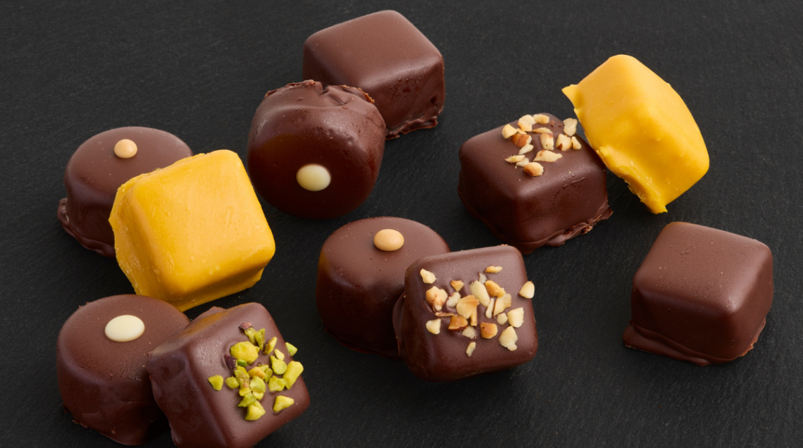 In primo piano, gelato pralina Il Milanese, color giallo zafferano, insieme ad altre praline al cioccolato