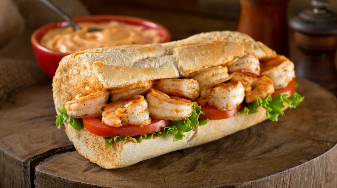 Panino Po' Boy con gamberi alla griglia e farcito con lattuga, pomodoro e salsa remoulade.