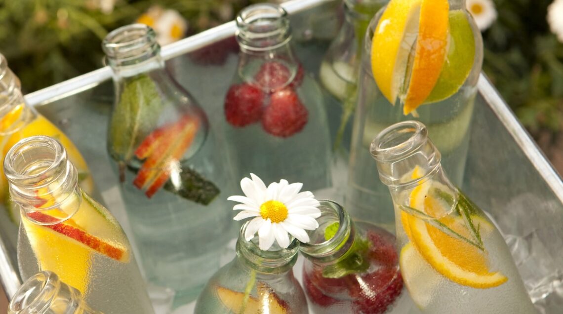 bottiglie con acqua, frutta e fiori