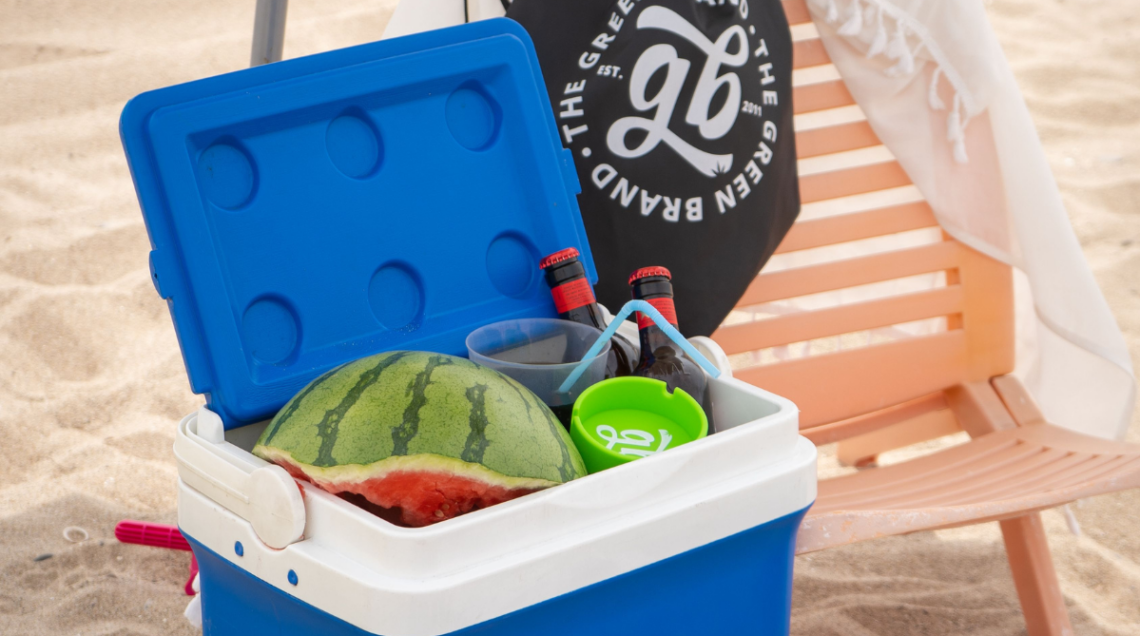 borsa frigo blu contenente anguria, birre e porta cenere per un fresco pranzo in spiaggia