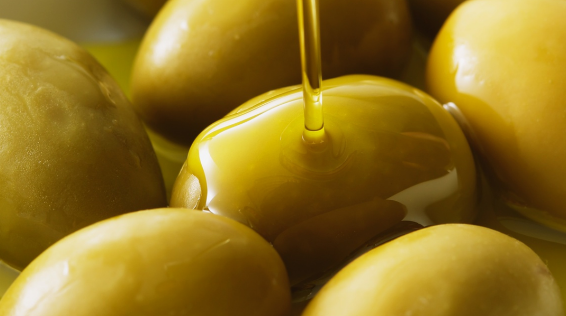 Olive ascolane verdi intere su cui viene versato un filo di olio d'oliva extravergine