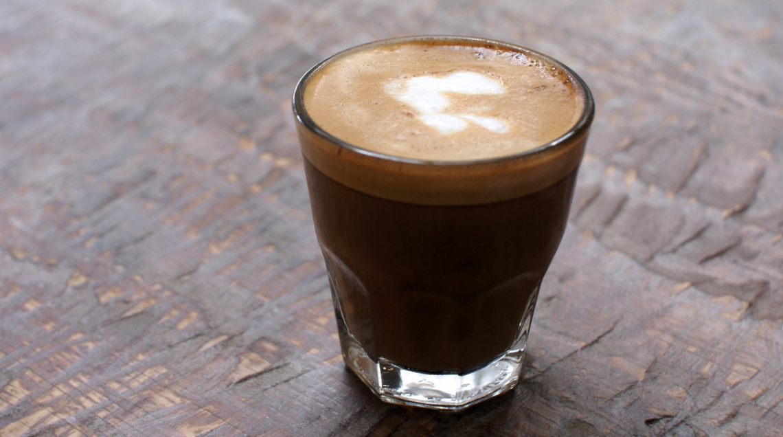 un bicchiere trasparente contenente il cortado