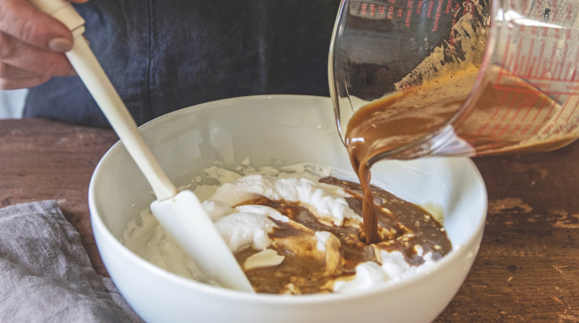 ciotola bianca con panna in cui viene versato del caffè. Vi è anche appoggiata una marisa
