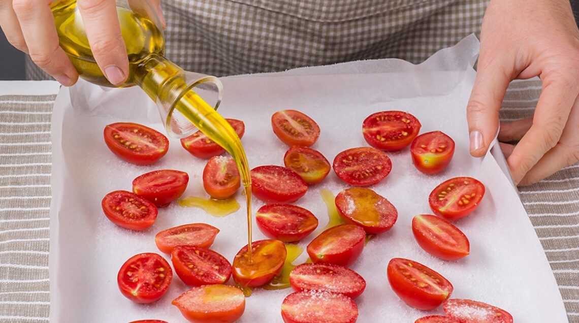 mezzi pomodorini su una teglia cosparsi di olio