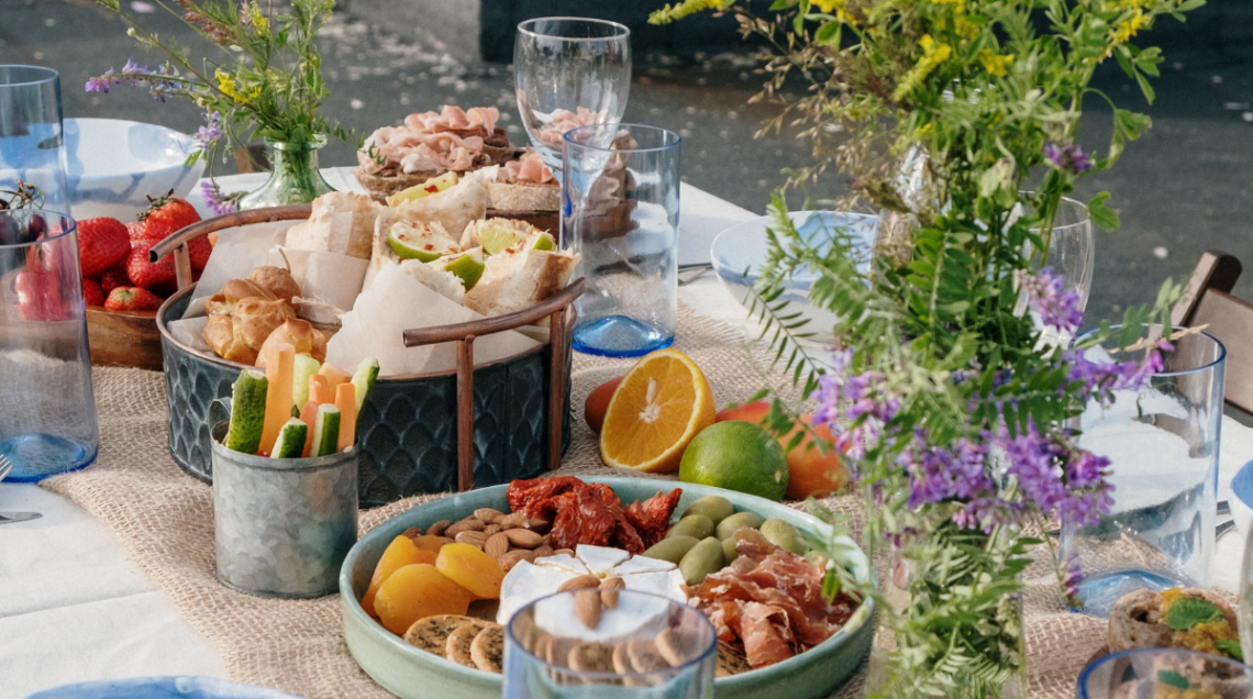 Tavola imbandita all'aperto con una varietà di antipasti e snack.