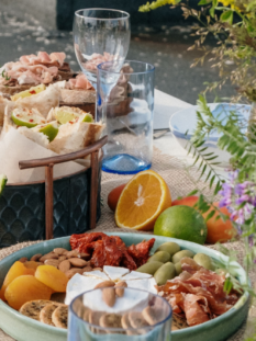 Tavola imbandita all'aperto con una varietà di antipasti e snack.